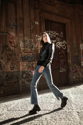 a lady in a black leather jacket and a pair of jeans